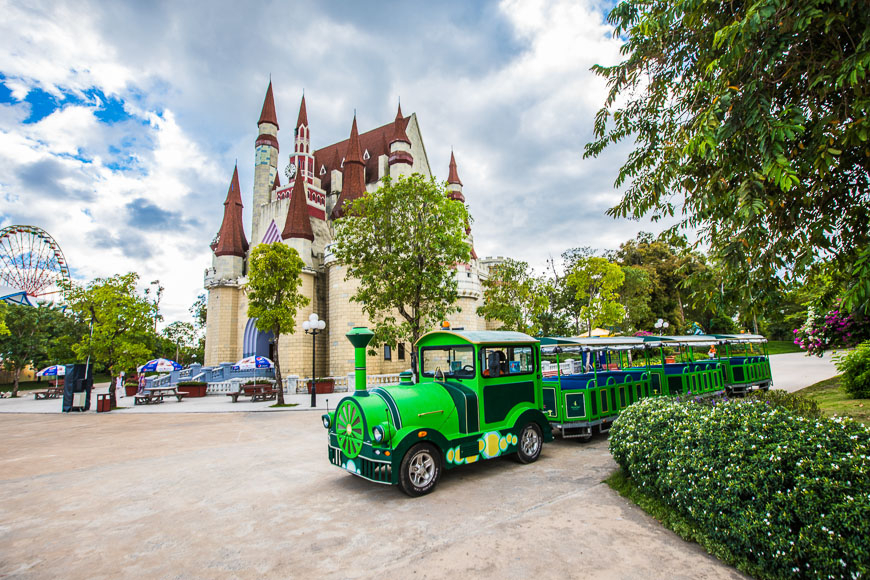 푸꾸옥 여행 필수 코스인 빈펄랜드 또는 선월드 내 테마파크 건물과 관광객을 태우는 기차의 모습입니다.