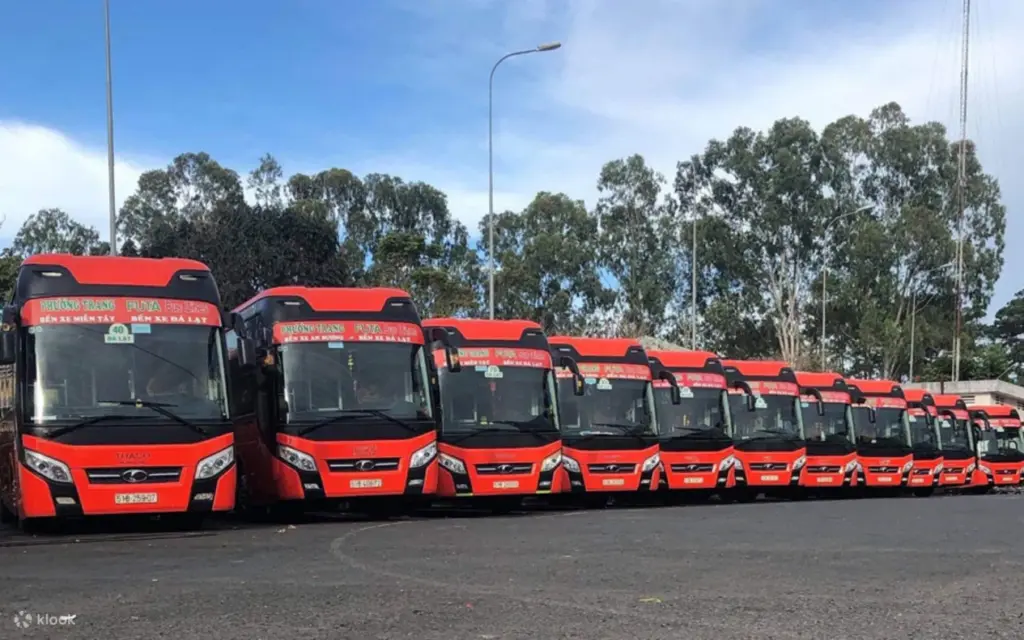 껀터 싸게 가는 방법 중 하나인 슬리핑 버스 (Sleeping Bus) 차량들이 주차장에 줄지어 서 있는 모습입니다. 빨간색의 깨끗한 버스들은 장거리 여행을 저렴하고 편안하게 할 수 있는 이동 수단입니다.