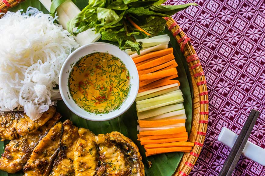 사파 당일치기 미식, 생선구이, 쌀국수, 채소 등이 조화된 베트남 전통 음식을 대나무 쟁반에 담아낸 모습 .